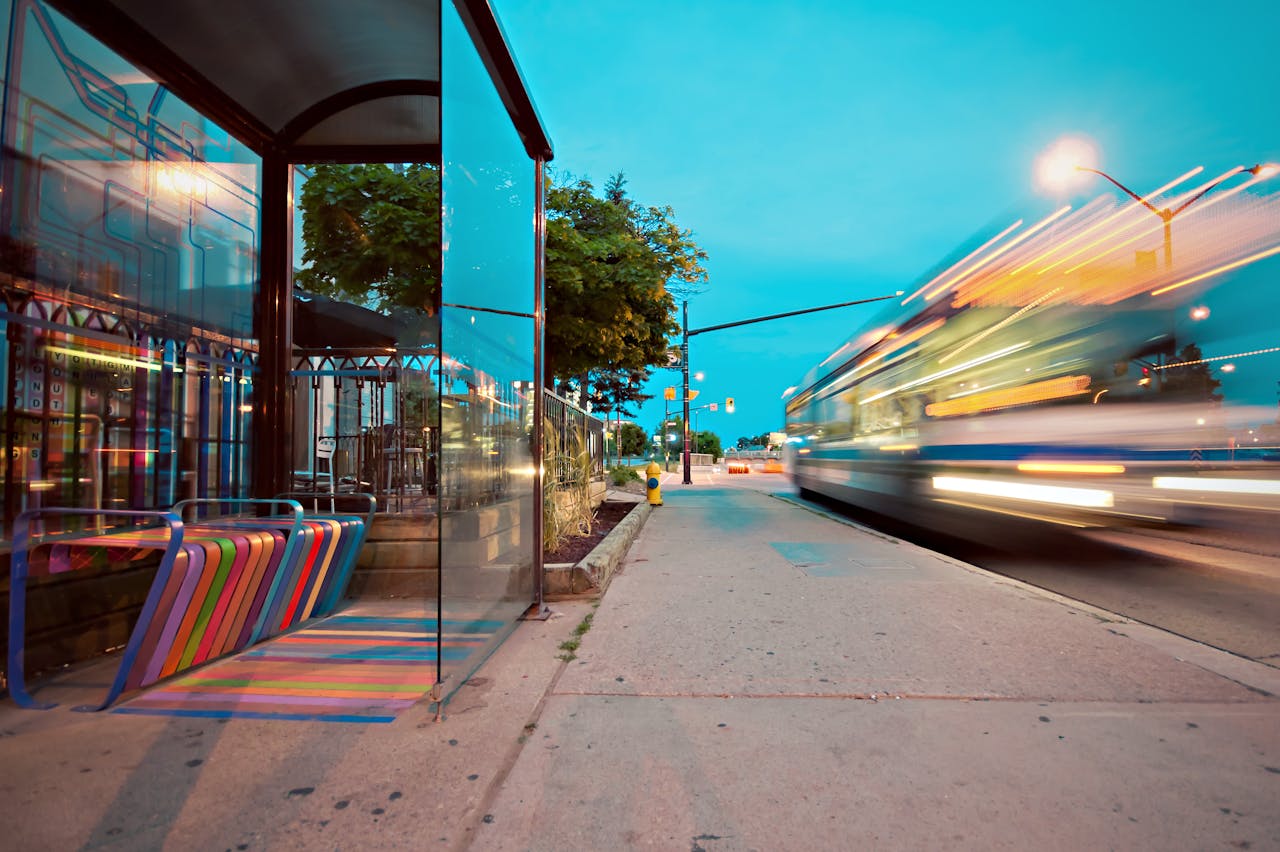 digital Colorful city bus stop with vibrant benches, blurred motion of a passing bus at dusk.